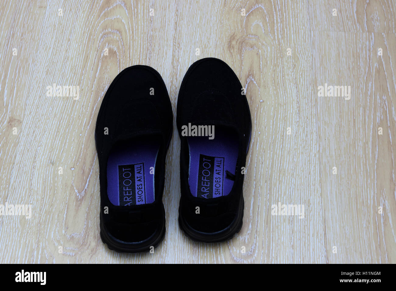 Schwarze Schuhe auf Holzboden Stockfoto