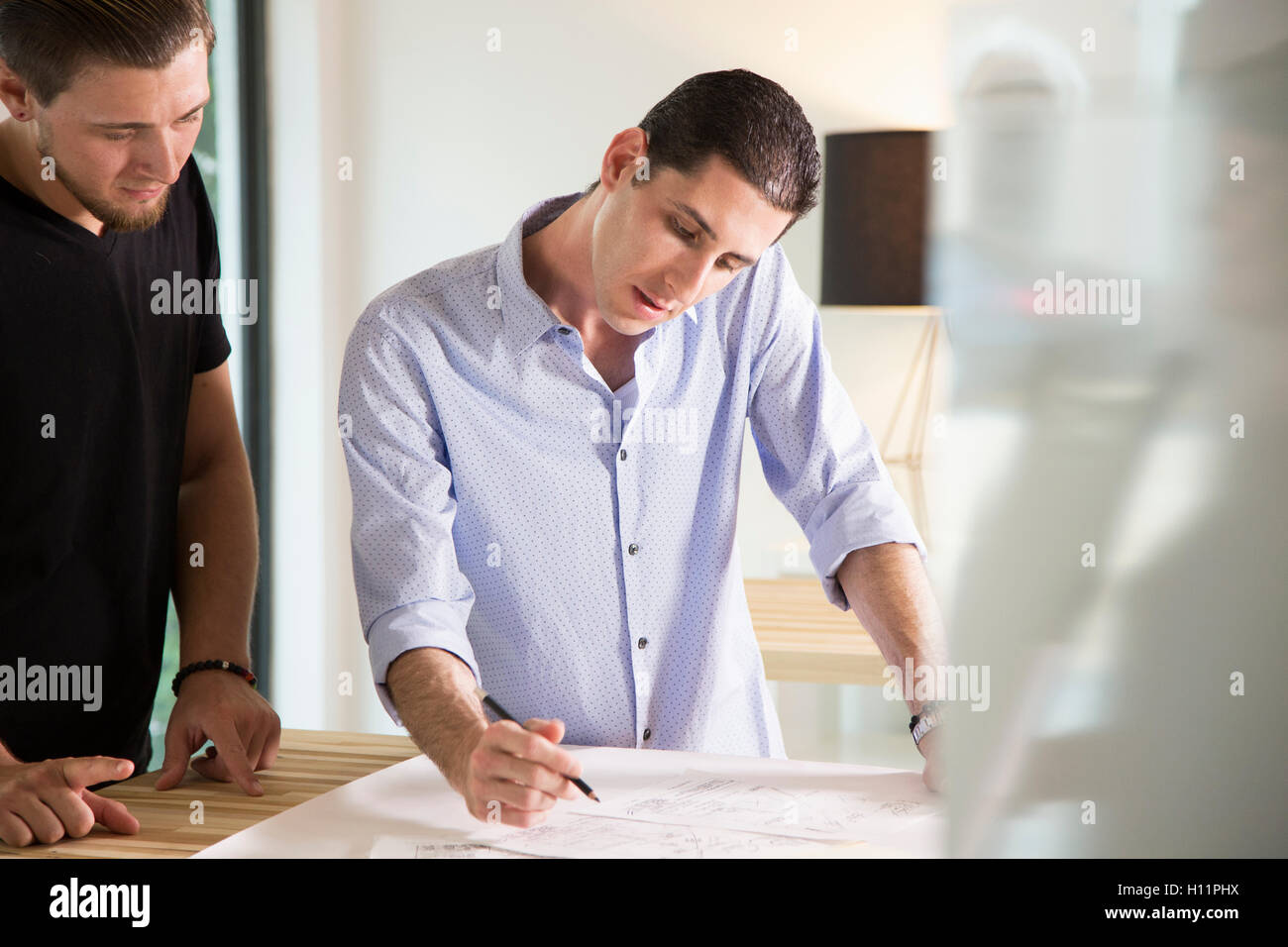 Zwei männliche Büroangestellte, Austausch von Ideen in einem modernen Büro Stockfoto