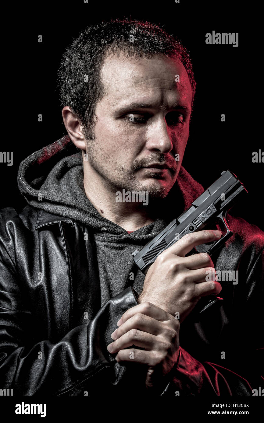 Housebreaker, Dieb, bewaffneter Mann mit schwarzer Lederjacke, Gefahr Stockfoto