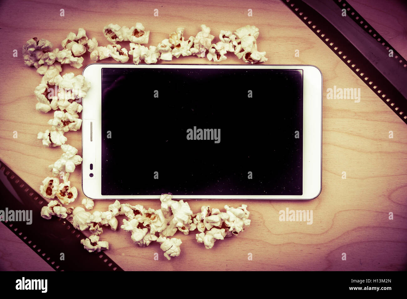 Tablet-pc auf Holz mit Attributen des Kinos. Stockfoto