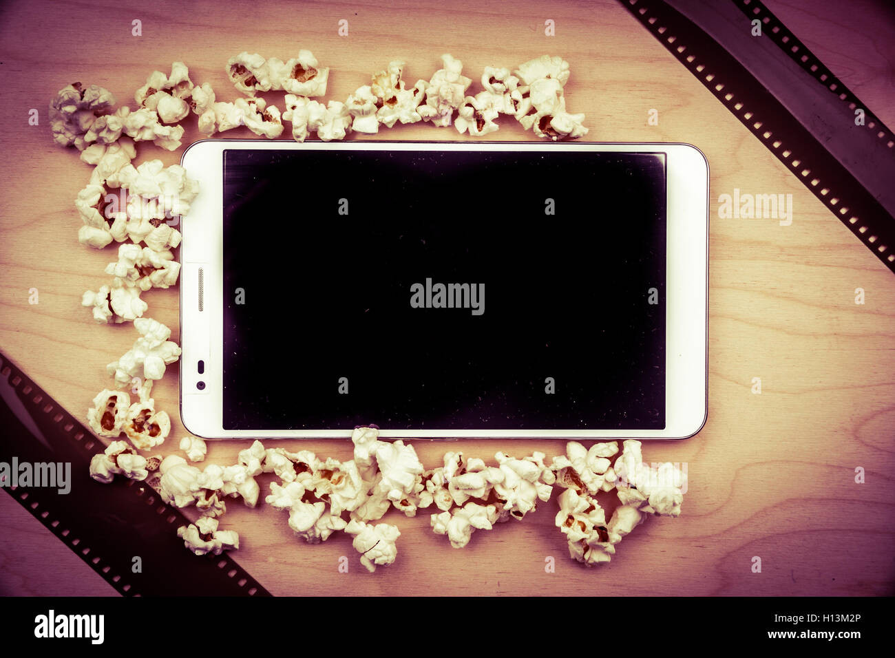 Tablet-pc auf Holz mit Attributen des Kinos. Stockfoto