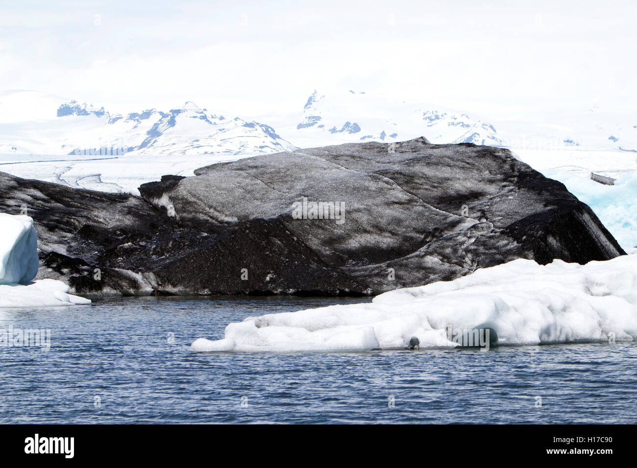 großen Asche bedeckte Eisberg an die Gletscherlagune Jökulsárlón Island Stockfoto