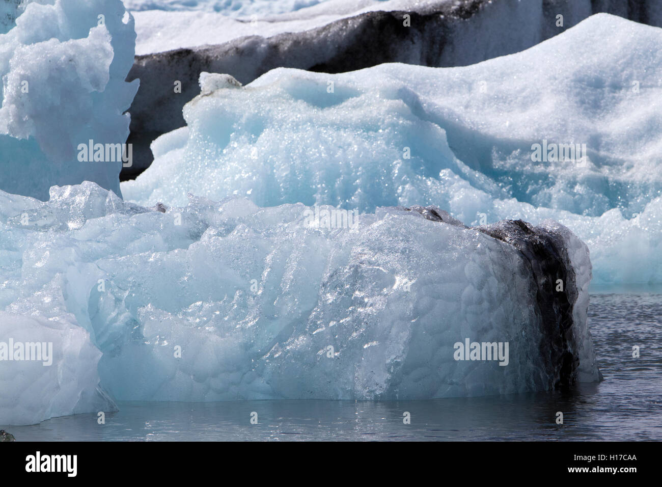 Wasser getragen umgedreht Eisberg mit eingebetteten Asche Jökulsárlón Gletscherlagune Islands Stockfoto