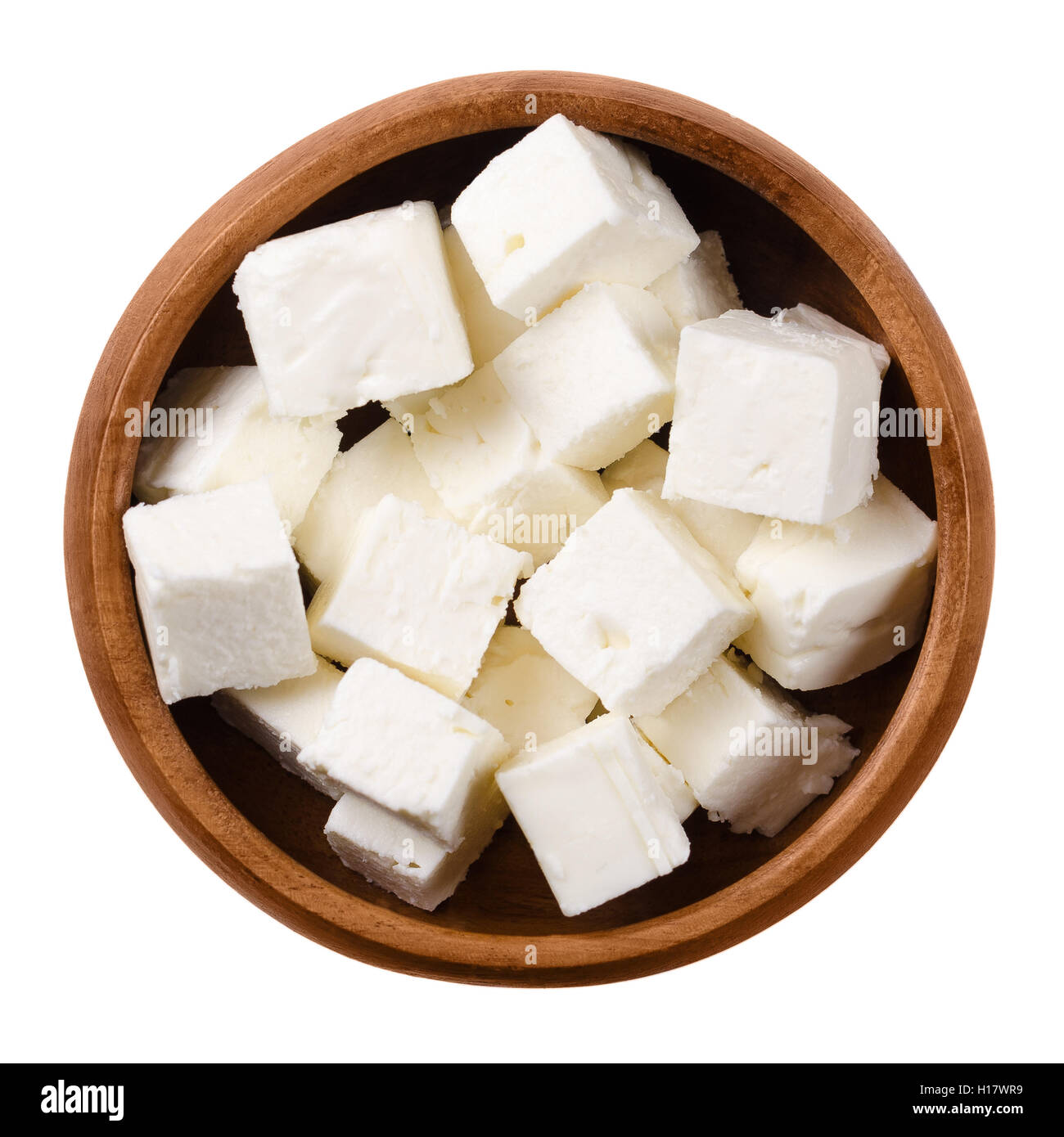 Griechischer Feta Käsewürfel in einer Holzschale auf weißem Hintergrund. Käsewürfel eine weiße brined Quark made in Griechenland. Stockfoto