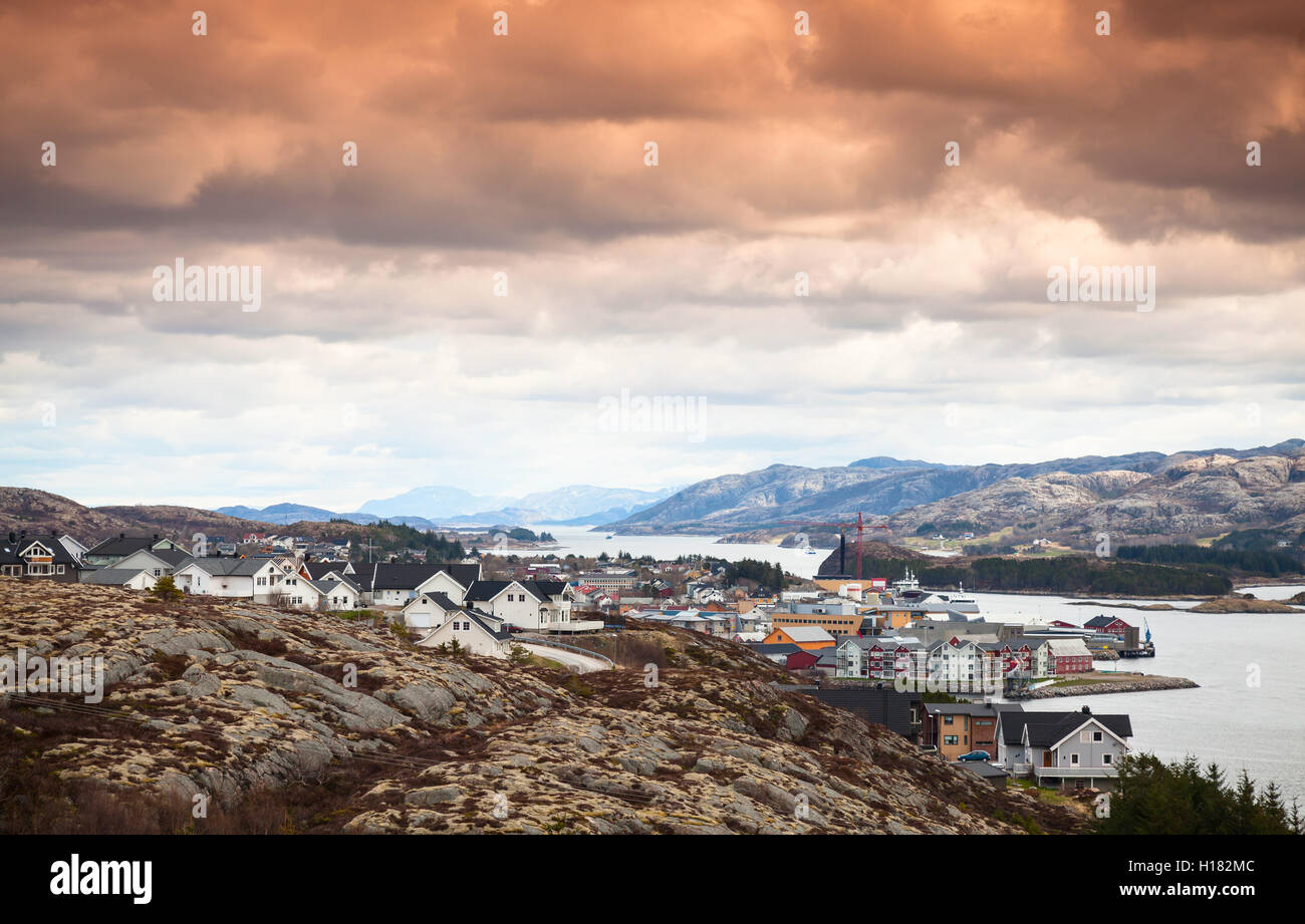 Norwegische Küstenlandschaft. Fischerdorf mit bunten Häusern unter bunten dramatischen Wolkenhimmel. Rorvik, Norwegen Stockfoto