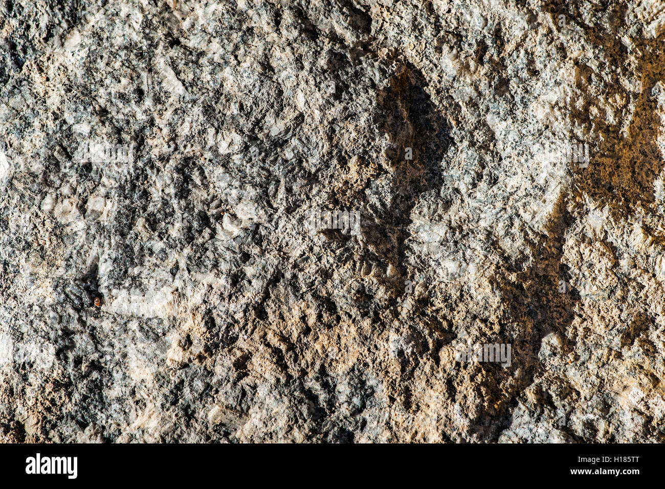 Sonnendurchflutetes Granittextur mit Sand verunreinigt. Stein oder Fels Muster oder Hintergrund. Stockfoto