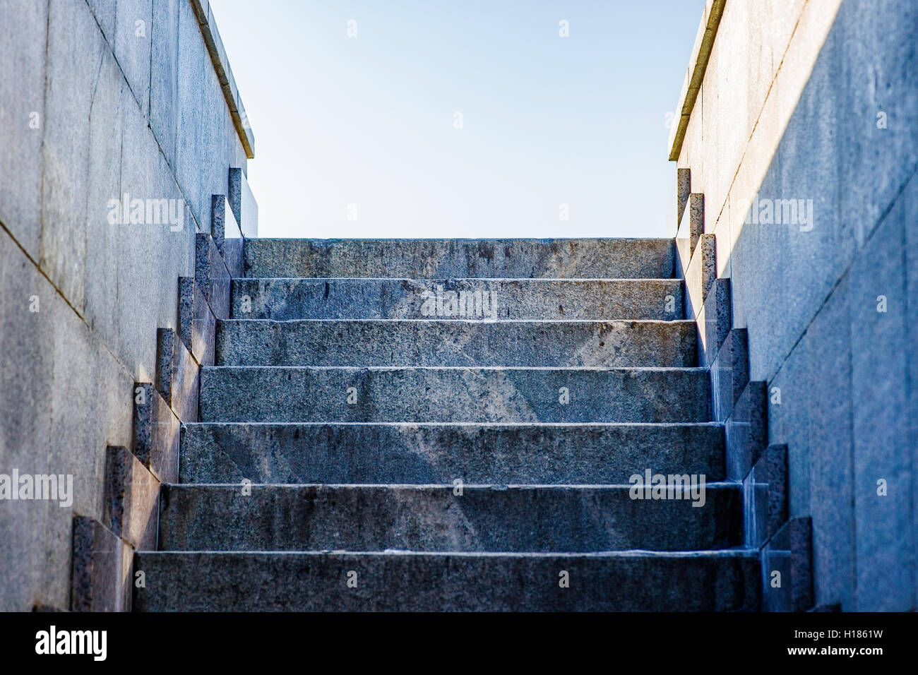 Stufen aus Granit und Wände zum blassen blauen Himmel. Freiraum zur Texteingabe. Stockfoto