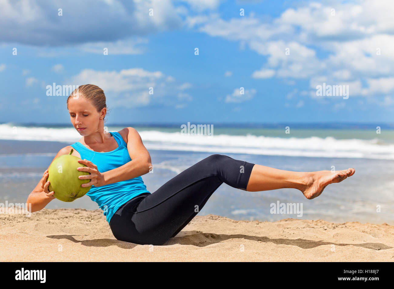 Passen Sie Frau Trainieren Bauch Muskel Am Ocean Beach Dabei Knirscht Kern Bein Heben Ubungen Mit Kokosnuss Gewicht Verdrehen Stockfotografie Alamy