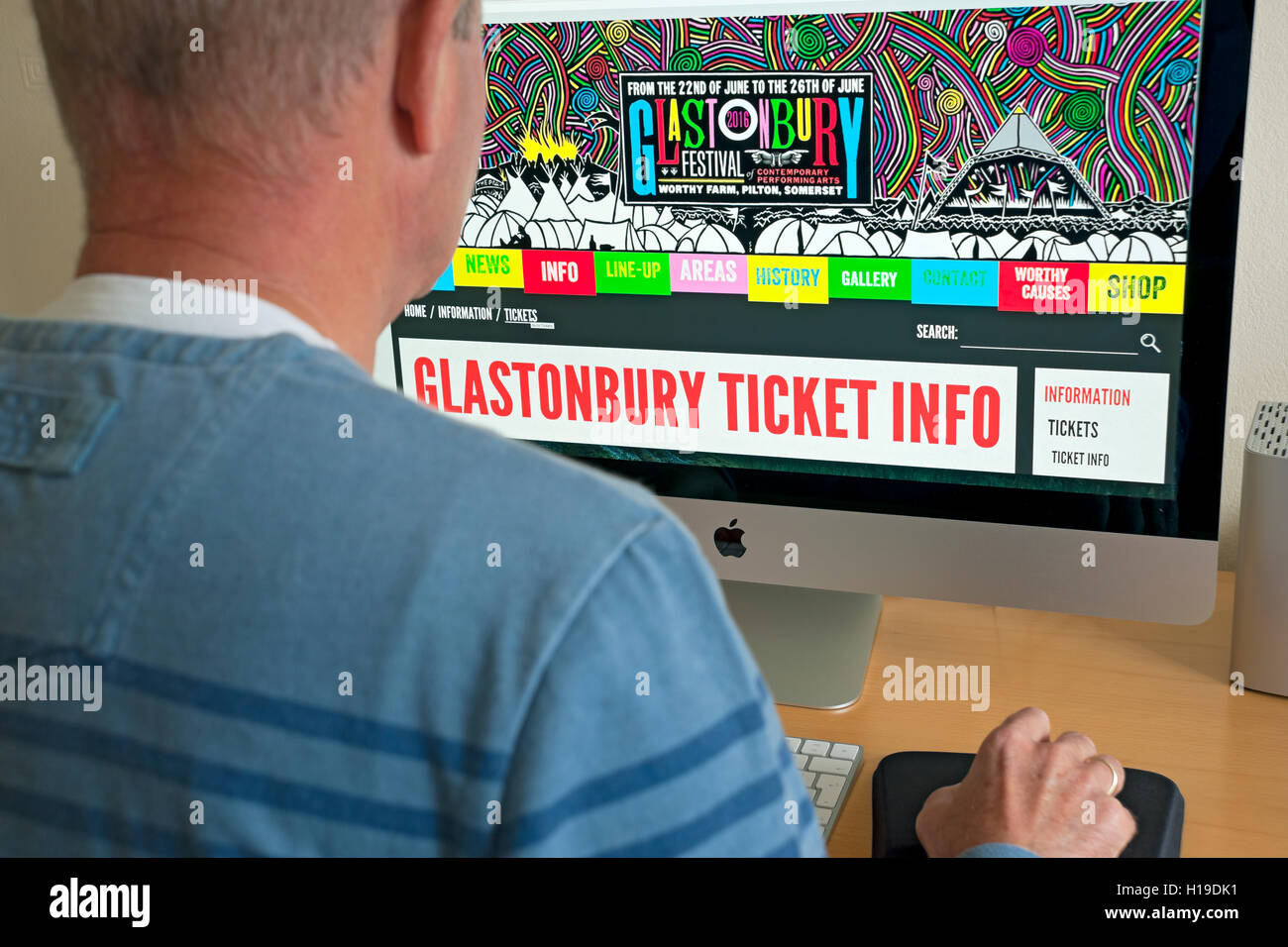 Mann, Blick auf Glastonbury Festival Website auf Computer Bildschirm England UK United Kingdom GB Great Britain Stockfoto