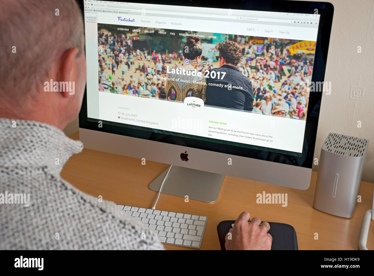 Mann Person, die auf der Latitude Festival Website auf dem Computerbildschirm England Großbritannien Großbritannien GB Großbritannien Stockfoto