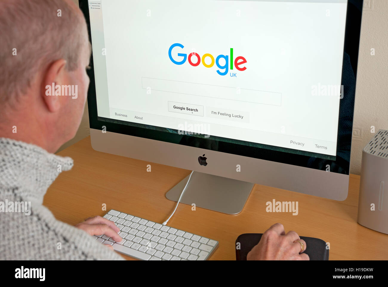Mann Person, die auf der Homepage der Google UK Website auf dem Computerbildschirm im Internet anschaut Großbritannien Großbritannien Großbritannien Großbritannien Großbritannien Großbritannien Großbritannien Stockfoto