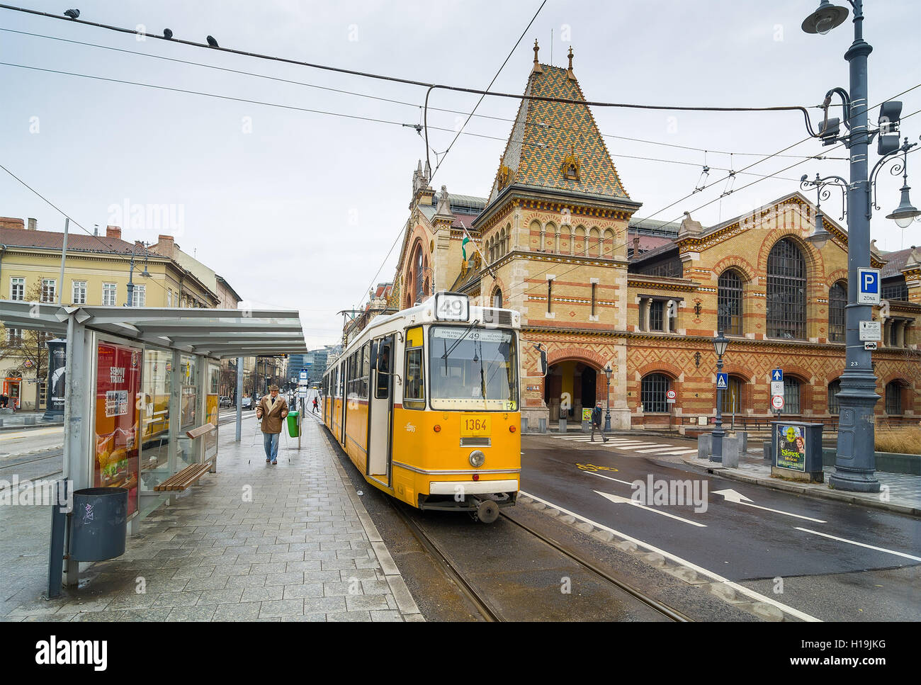 BUDAPEST, Ungarn - 21. Februar 2016: Gelbe Straßenbahn und große Markthalle in Budapest, Ungarn. Stockfoto