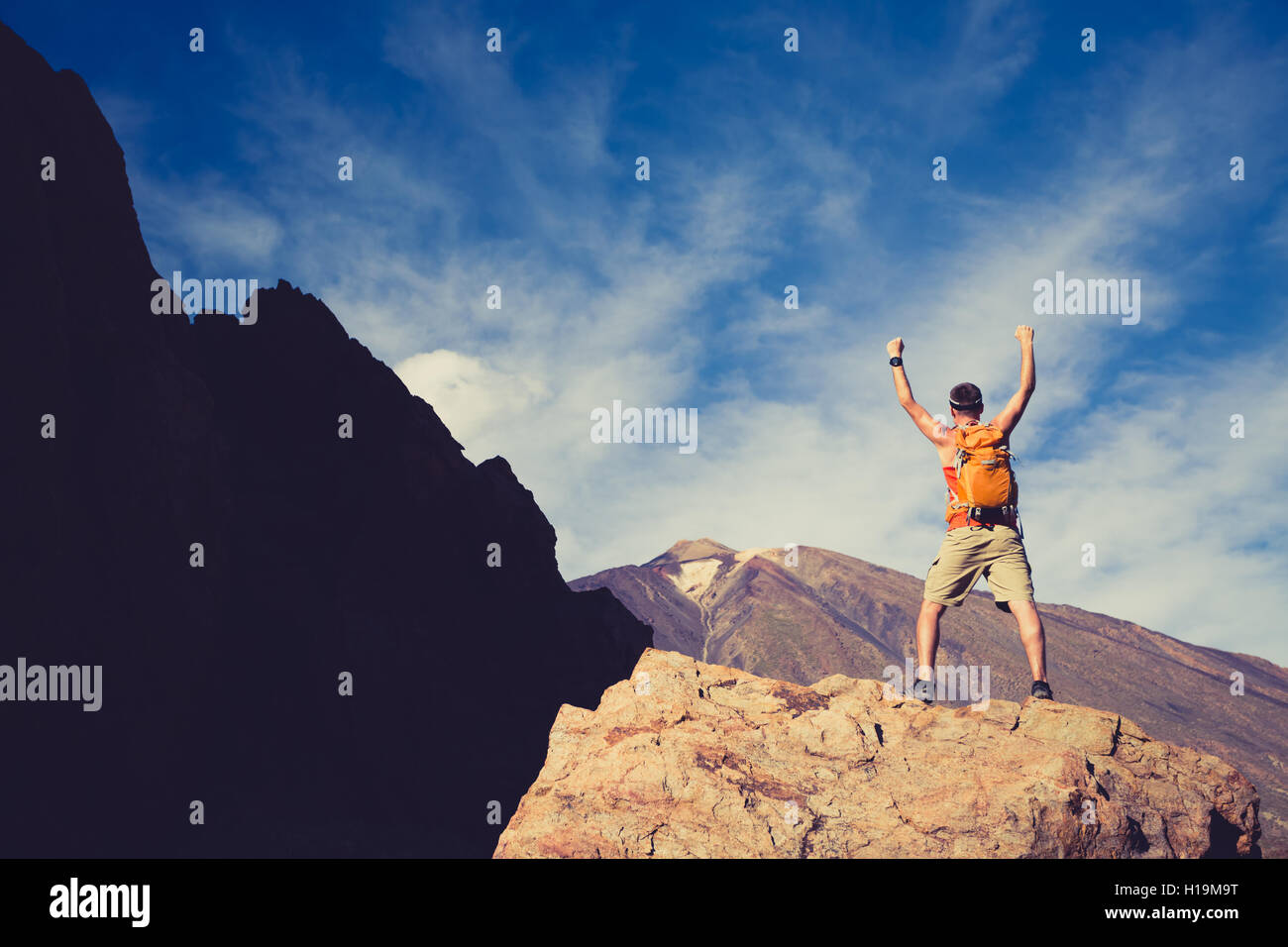 Mann mit ausgestreckten Armen zu feiern schöne inspirierender Blick in Bergen. Männliche Wanderer oder Bergsteiger mit Händen oben genießen inspirat Stockfoto
