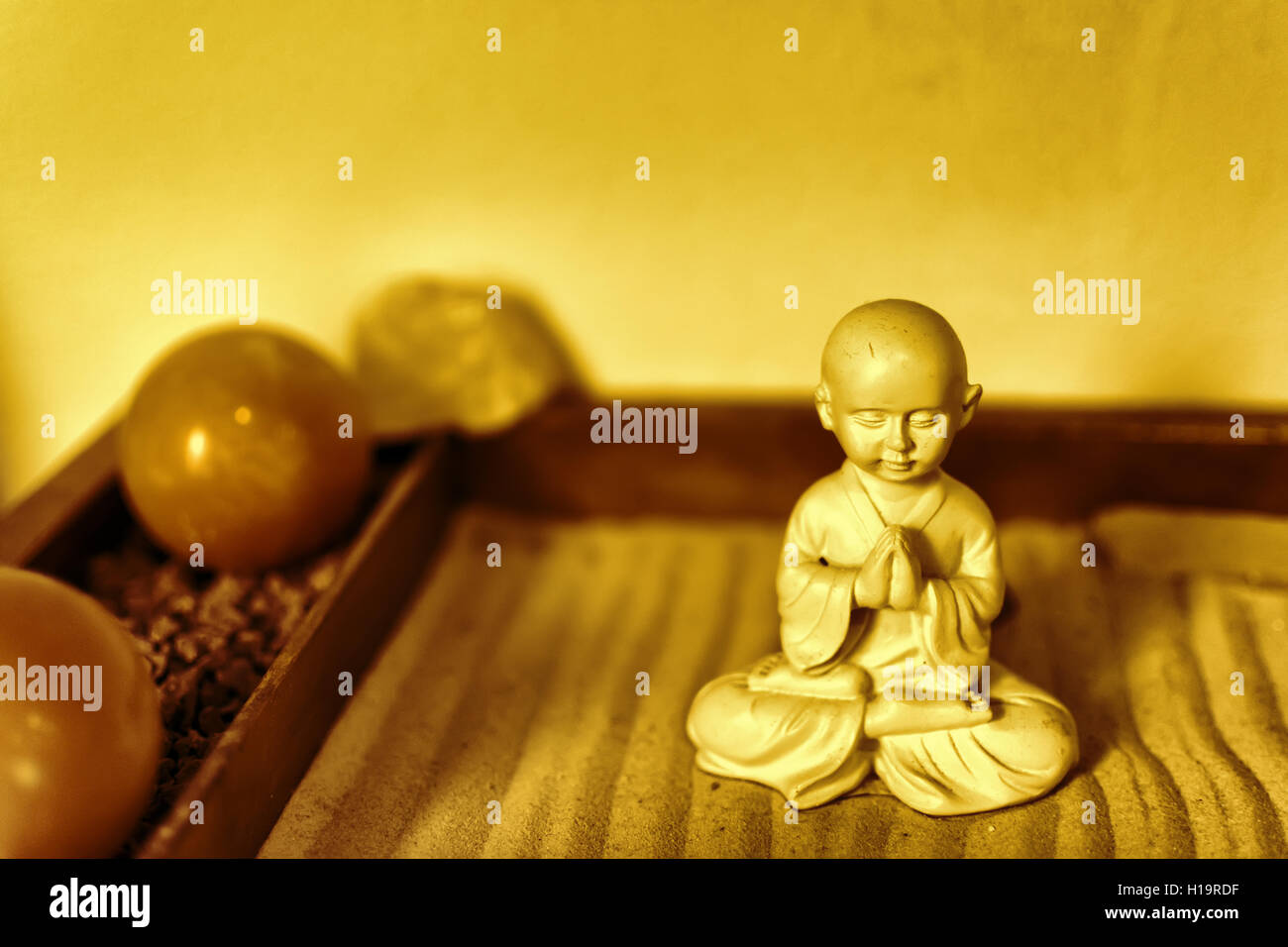 Buddha-Statue im Lotussitz sitzen auf dem Sand. Ayurveda-Konzept. Buddha im Zen-Garten mit weichen Linien in den Sand. Stockfoto