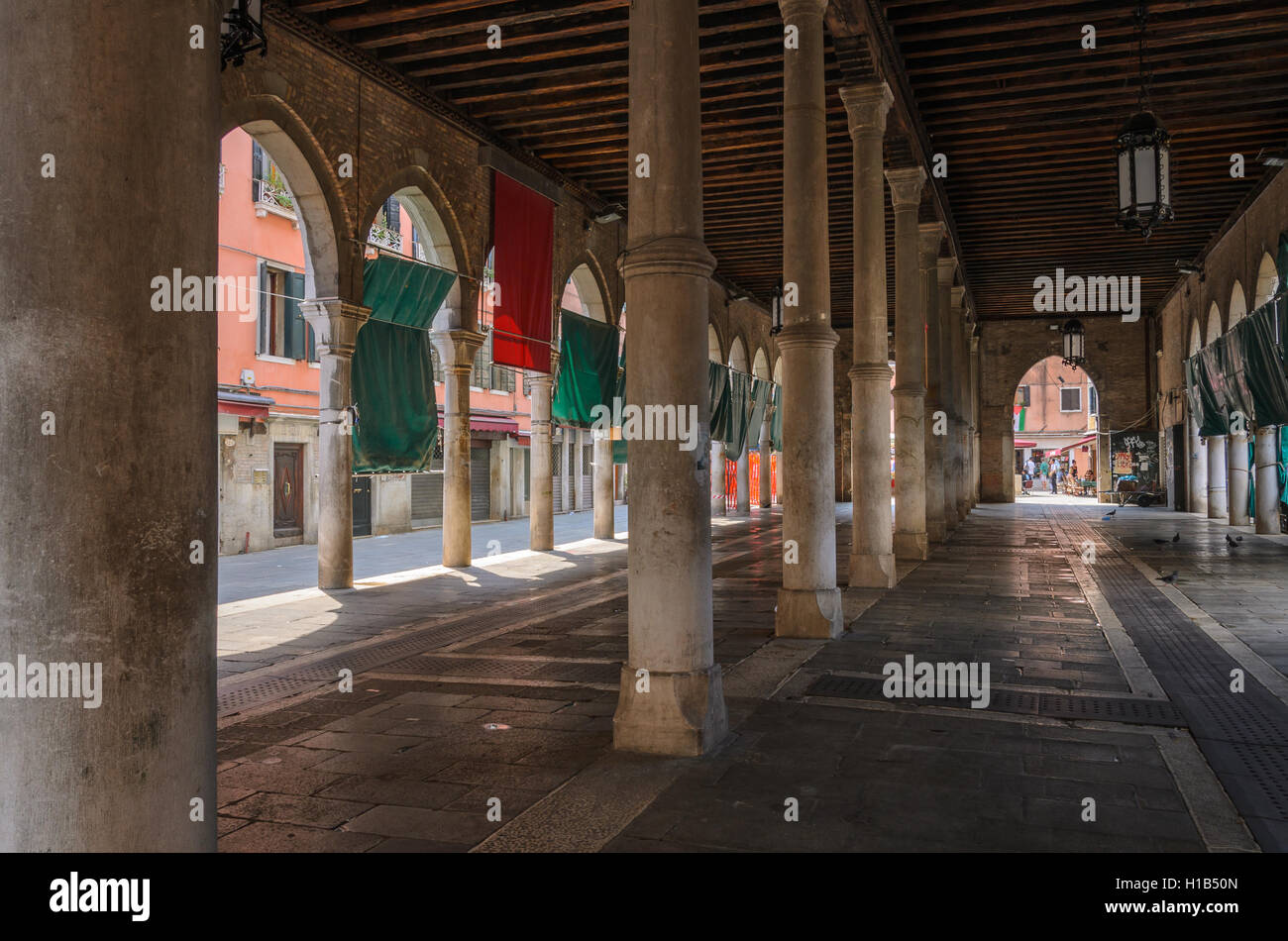 Ein großes Gebäude mit Säulen und Bögen und Menschen in der Ferne, Venedig, Italien. Stockfoto