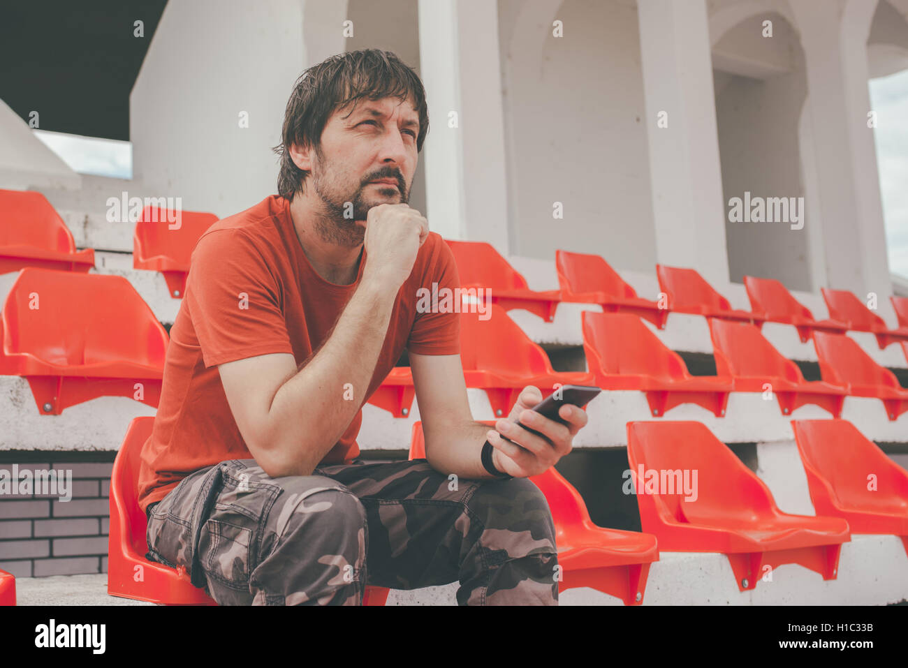 Enttäuschter Mann im Sportstadion das Spiel ungläubig beobachten, während seine Mannschaft das Spiel verliert Stockfoto