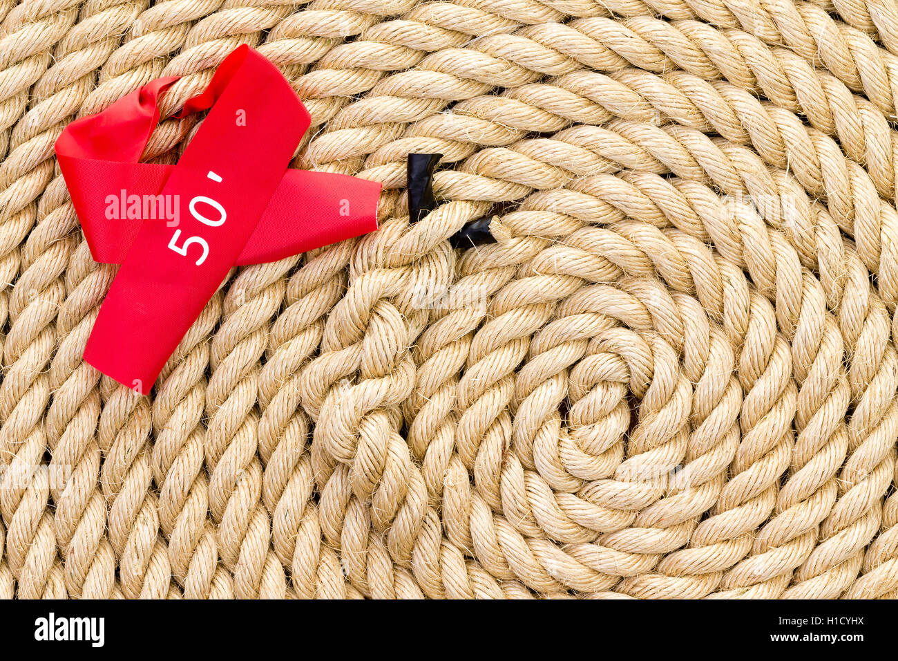 Neue starke Seil mit roten 50-Fuß-Marker und zentralen Knoten eine Tauziehen Herausforderung oder Wettbewerb ordentlich aufgerollt in einer Spirale in Stockfoto