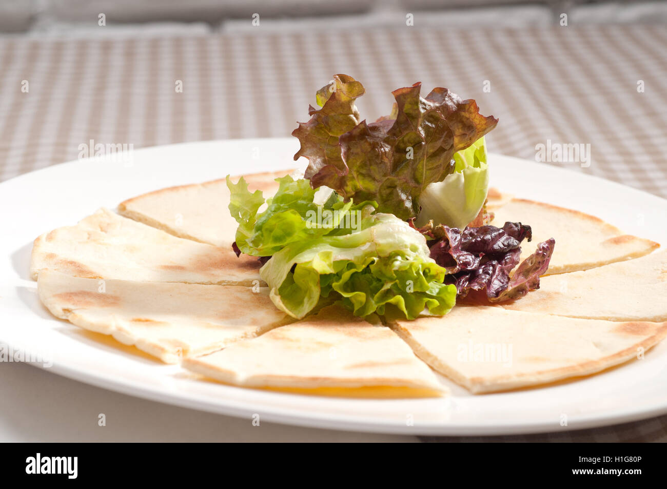 Knoblauch-Pita-Brot-Pizza mit Salat an der Spitze Stockfoto