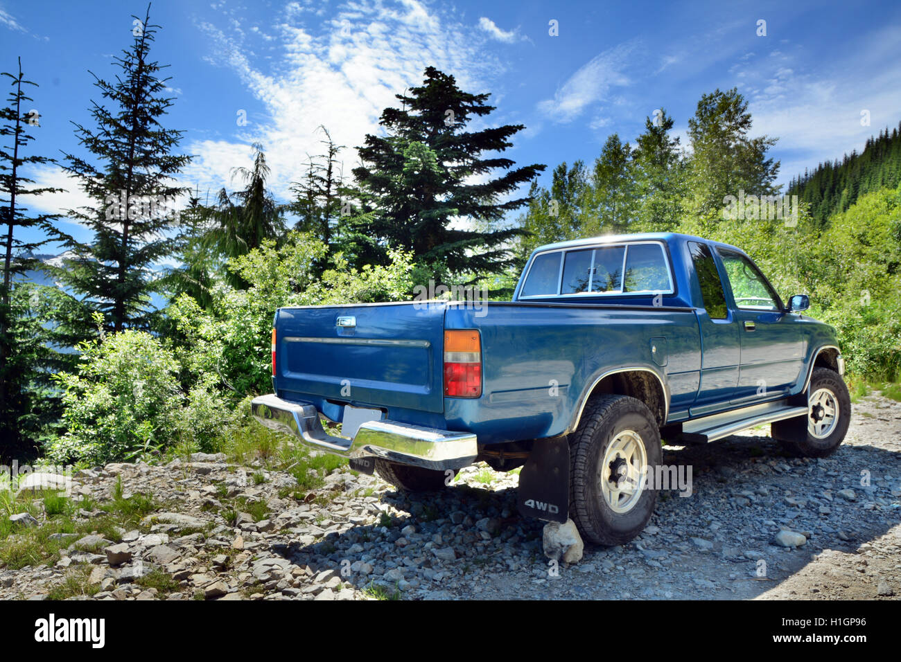 Hinten Seite von Blue Metallic LKW geparkt auf bergigen Wald Gravel Road in der Nähe von Sunny Whistler BC. HDR Art horizontale Foto Stockfoto