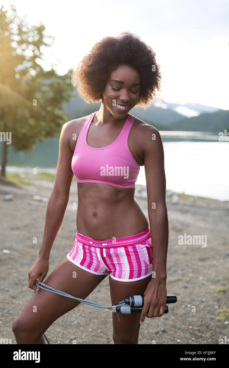 Sportliche junge afroamerikanische Frau training am Strand Stockfoto