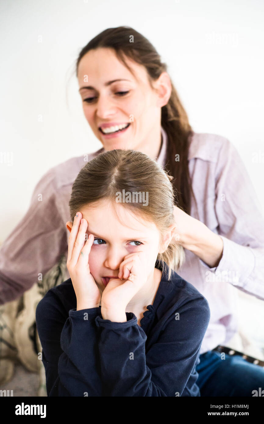 Mutter 6 jährige Tochter die Haare zu kämmen. Stockfoto