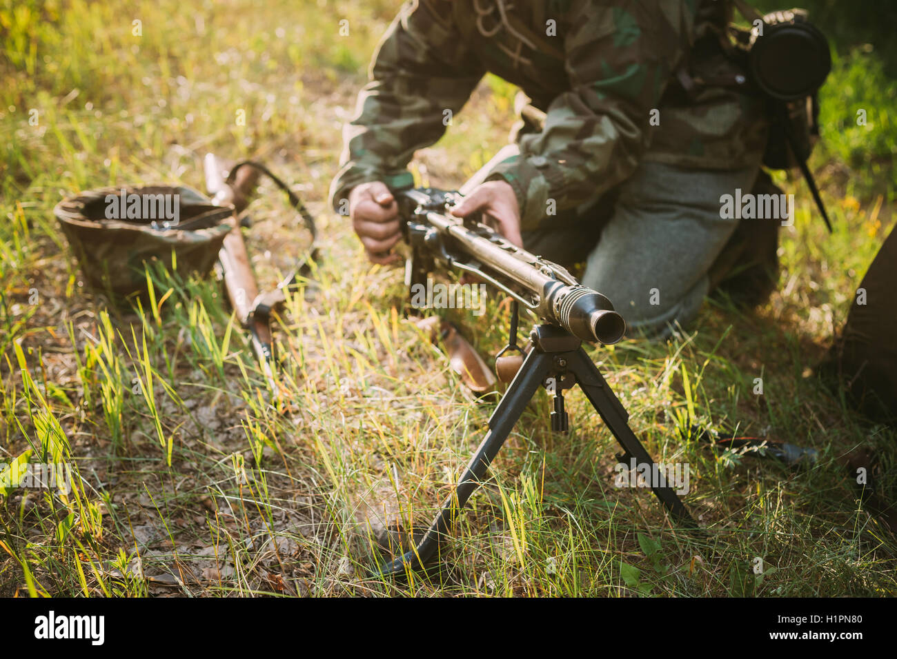 Nicht identifizierte Re Enactor gekleidet wie dem zweiten Weltkrieg deutsche Soldaten Maschinengewehr Nachladen ein Maschinengewehr im Sommer Wald Stockfoto