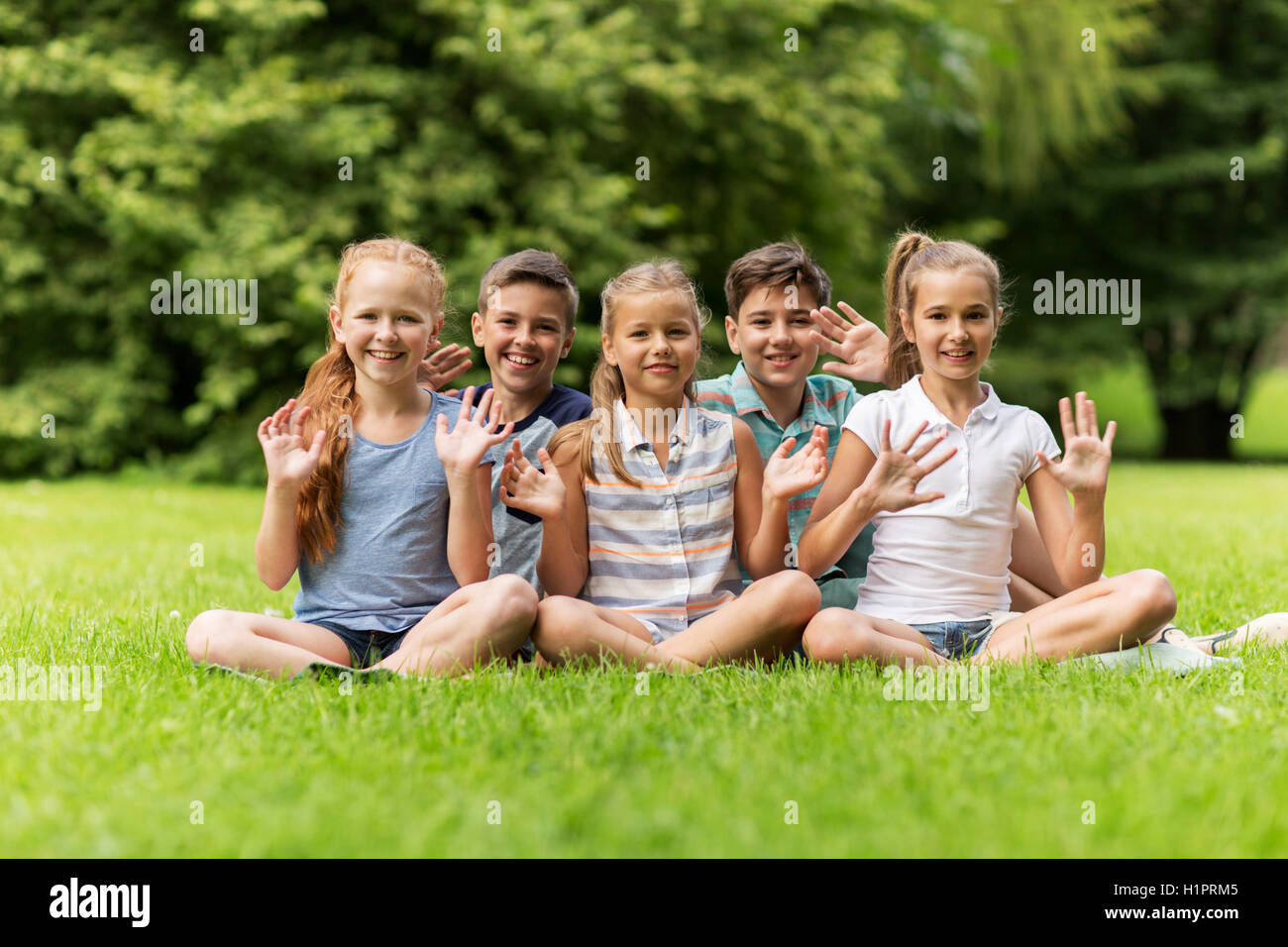 Gruppe von glückliche Kinder winken Hände im freien Stockfoto