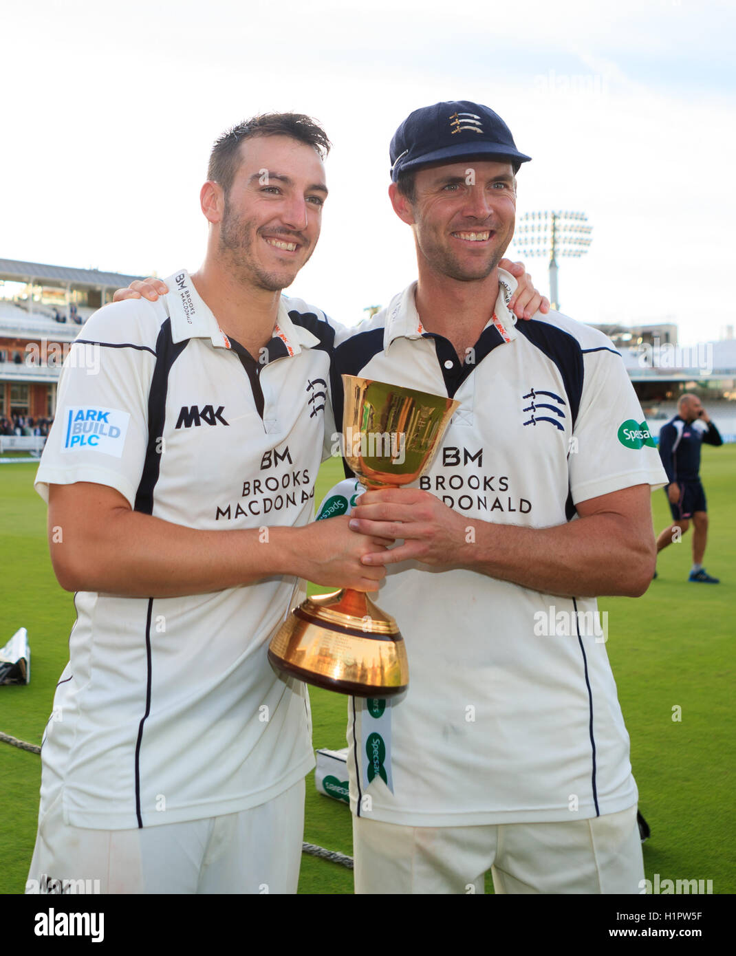 Die Middlesex Toby Roland-Jones und Kapitän James Franklin feiern mit der Trophäe tagsüber vier der Specsavers County Championship, Division One match bei Herrn, London. Stockfoto