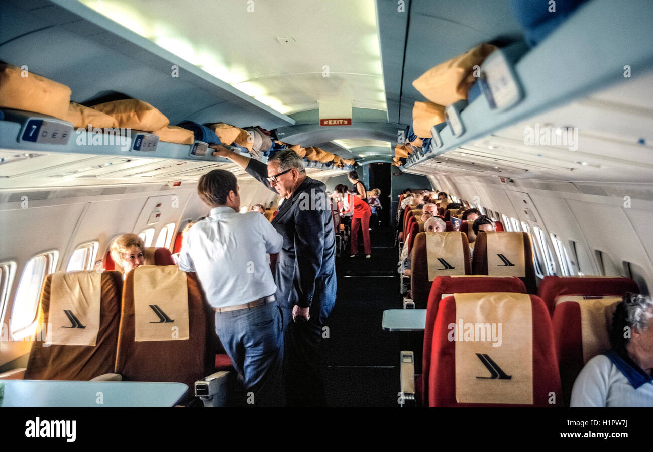 Zwei Reiseleiter (Vordergrund) stellen sicher, dass alle an Bord eine geräumige Convair 990 Jet zufrieden sind, die einen modernen Luftverkehr Charterflug genannt "Polar Vogel II." Das Flugzeug trug 48 Passagiere über dem Nordpol und Südpol auf eine eindeutige 32-Tag around the World Tour von Hemphill Welt Luft Kreuzfahrten in Los Angeles, Kalifornien, für die Travelers' Century Club. Es war die teuerste Tour der Zeit (1970) auf 9.760 $ pro Person. Stockfoto