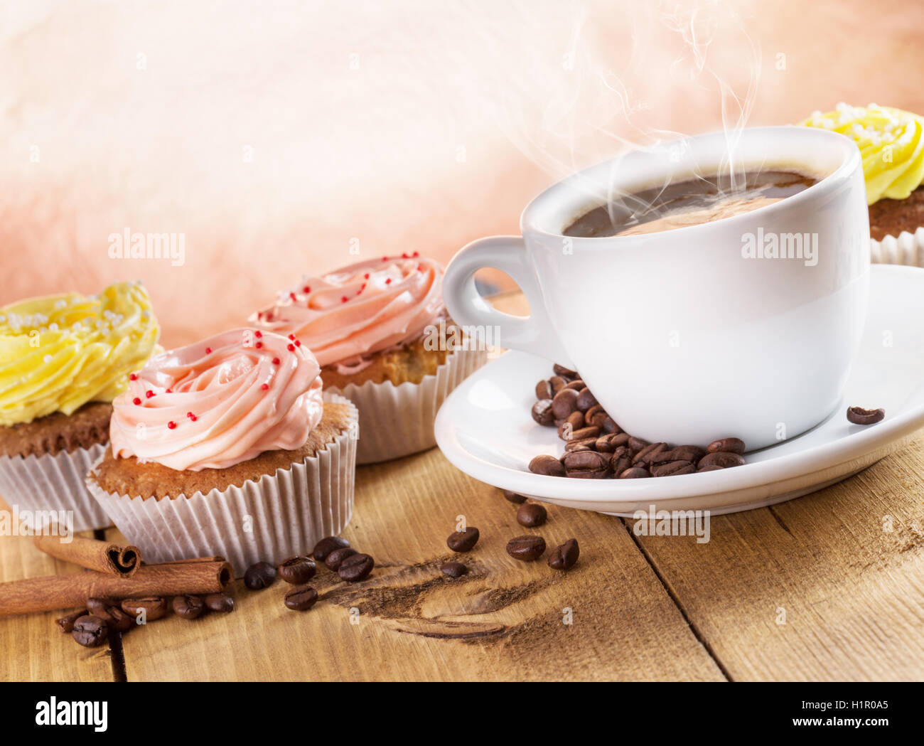 Tasse Kaffee und Muffins auf dem hölzernen Hintergrund. Stockfoto