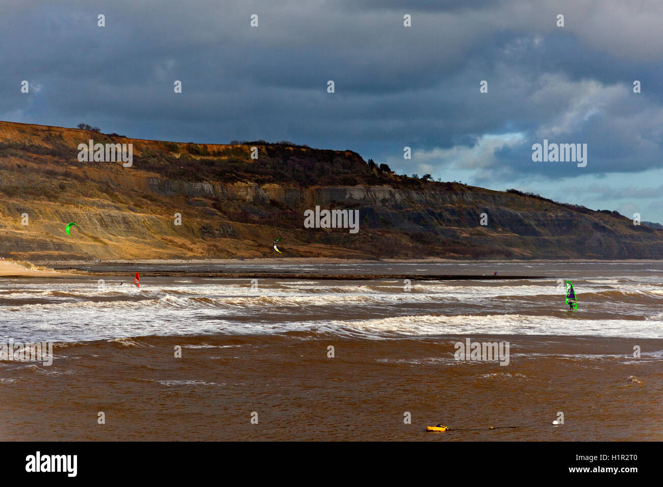 Windsurfer, das Beste aus den stürmischen Winterbedingungen bei Lyme Regis, Dorset, England, UK Stockfoto