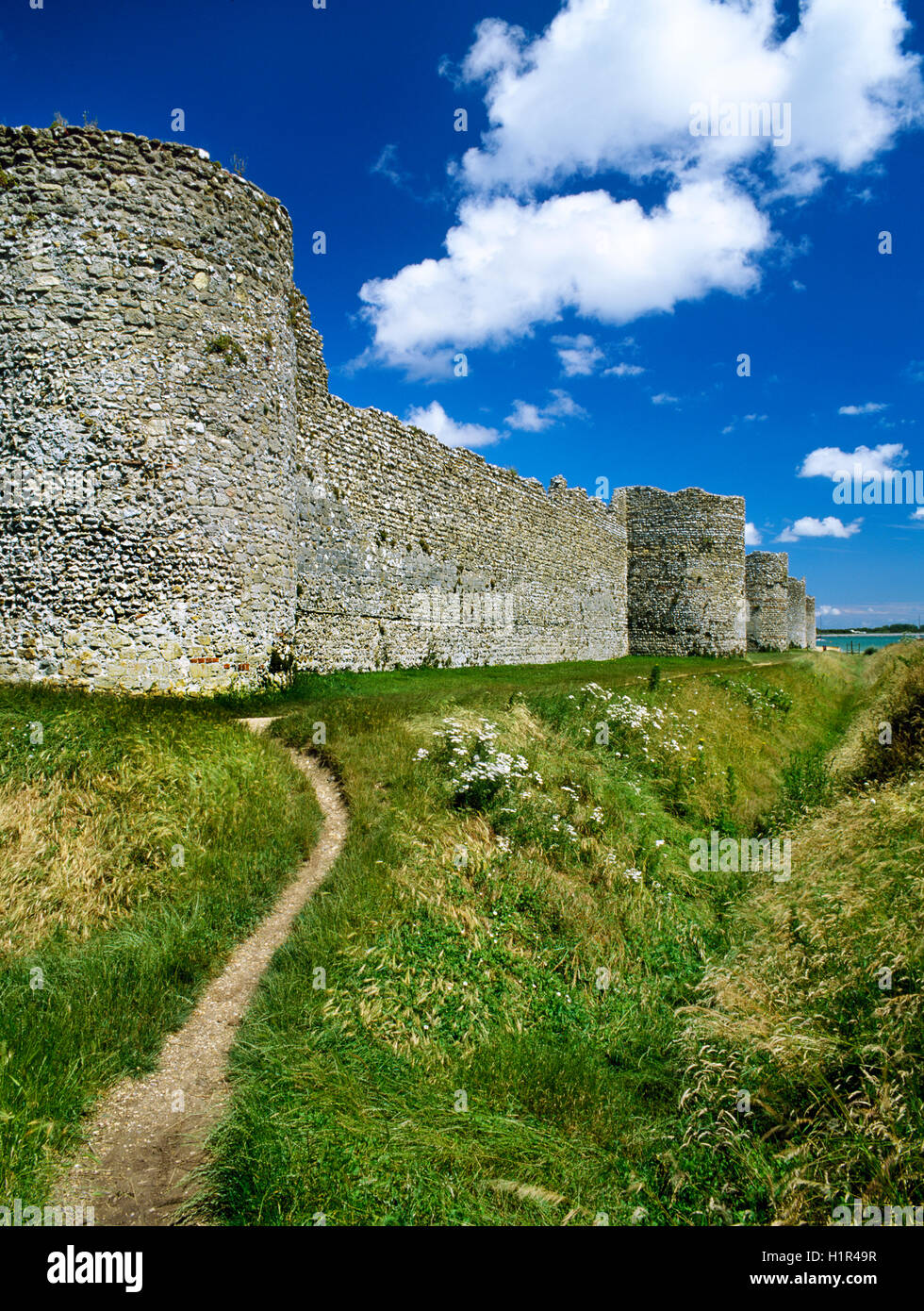 Ansicht E am südwestlichen Ecke Bastion (L) & S Wand Portchester späten C3rd römischen Kastells, Hampshire, England, mit hohlen Bastionen, externe Graben & Erdwall Stockfoto