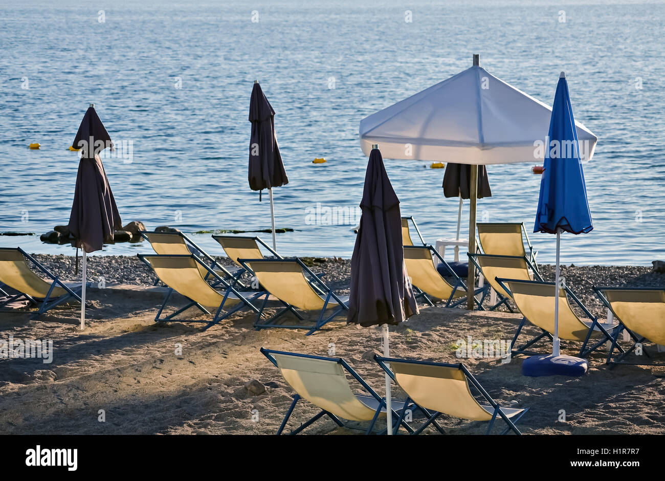 Einige Sonnenschirme und Stühle am Meer an einem schönen Sommertag Stockfoto