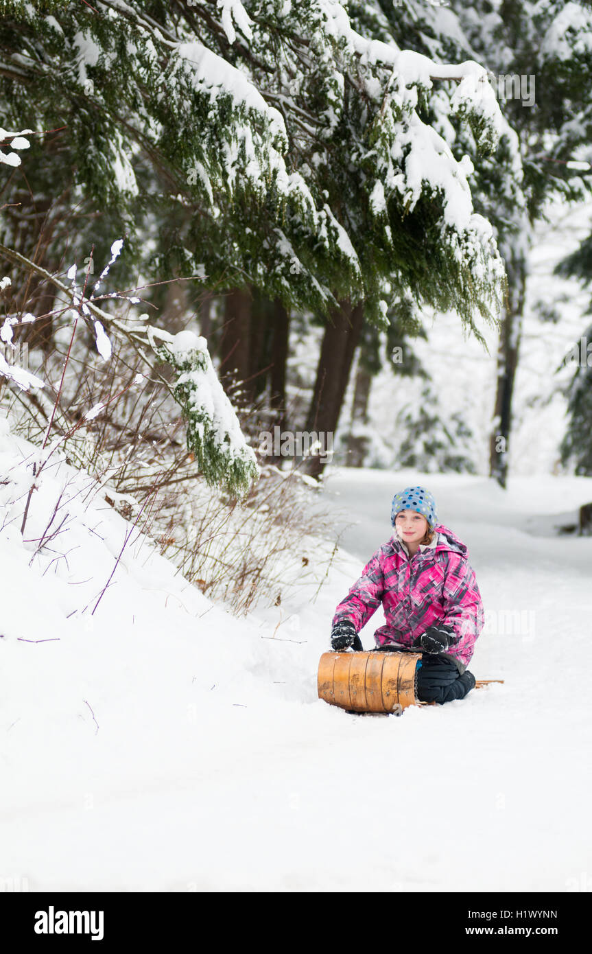 Mädchen an einem verschneiten Wintertag auf eine alte hölzerne Art Schlitten Rodeln Stockfoto