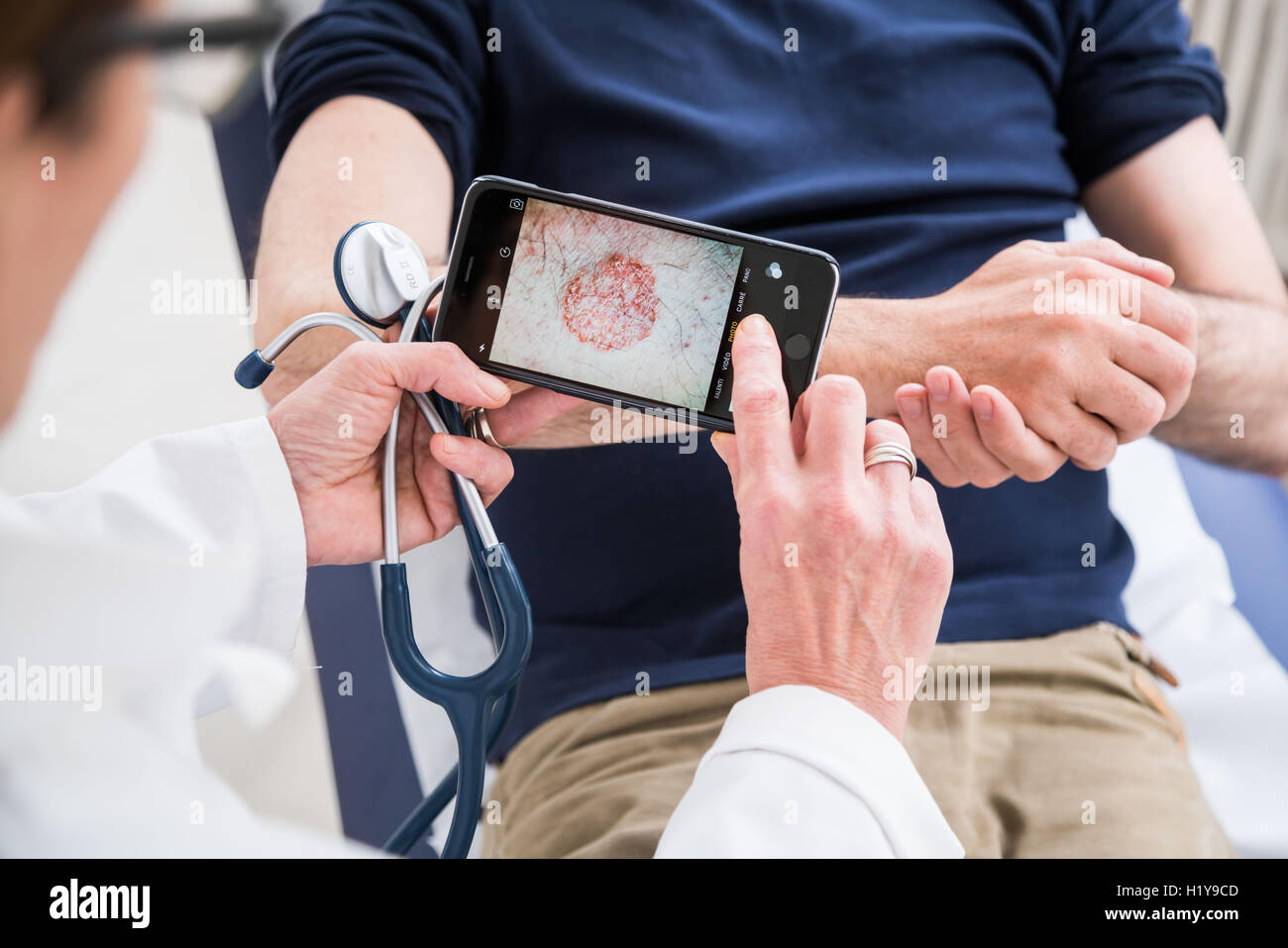 Arzt mit seinem Handy, um medizinische Daten zu übertragen. Stockfoto
