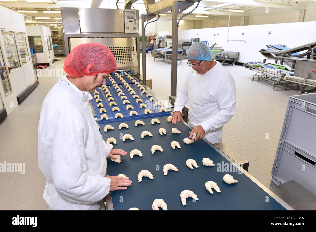 Arbeiter am Fließband in einer Auflaufform Fabrik mit croissants  Stockfotografie - Alamy