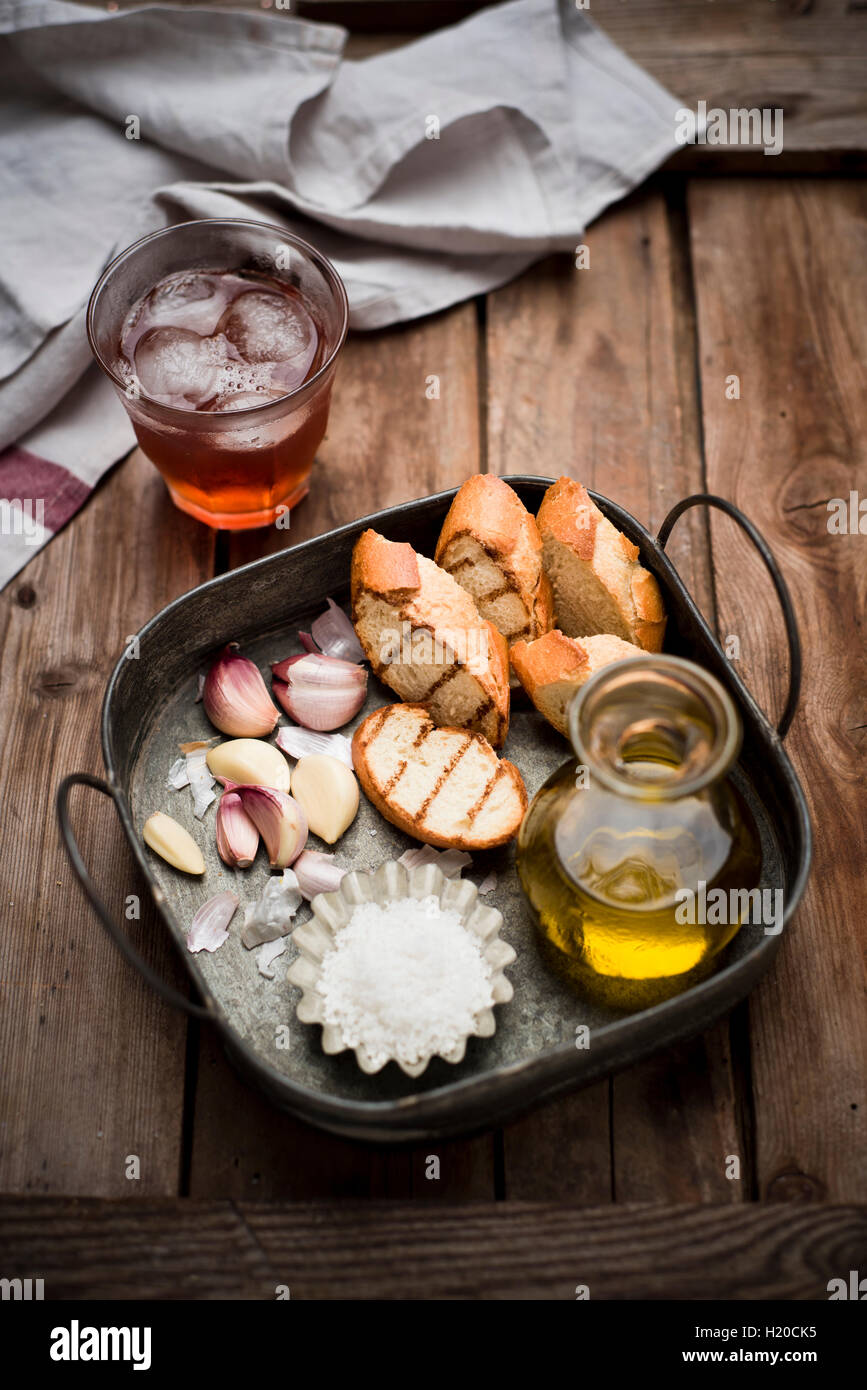 In Scheiben geschnittenen Knoblauch-Brot, Baguette, Knoblauch, Meersalz und Olivenöl auf Tablett Stockfoto