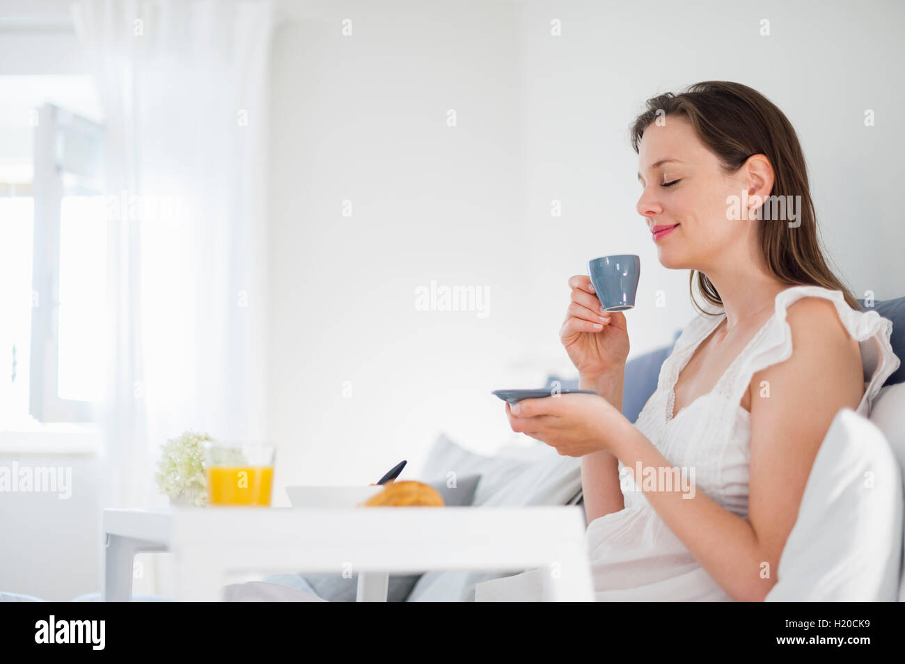 Frau im Bett mit Frühstückstablett Stockfoto
