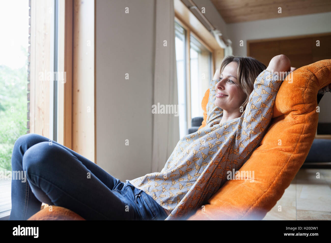 Lächelnde Frau in Sessel entspannen Stockfoto