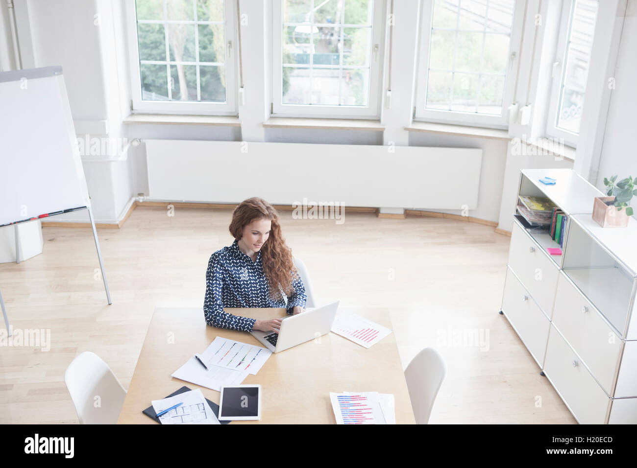 Frau mit Laptop im Sitzungssaal Stockfoto