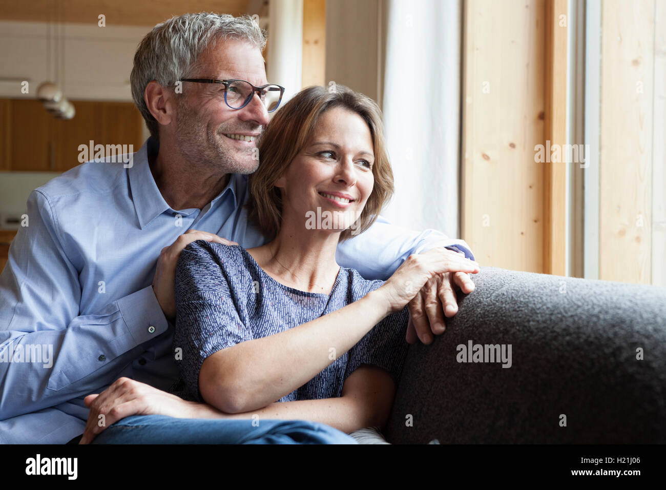 Lächelnde älteres Paar auf couch Stockfoto