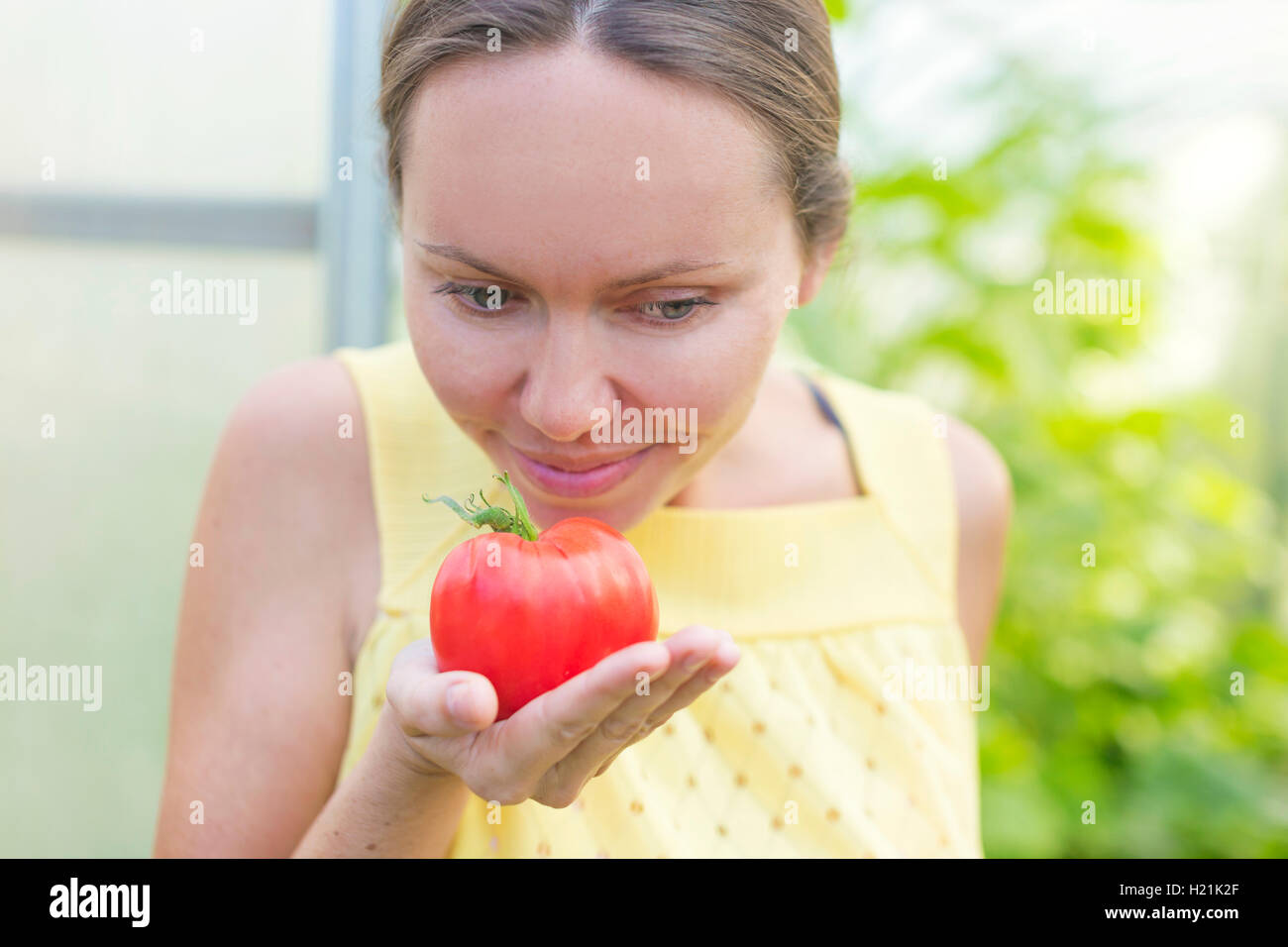 Frau riechen Tomate Stockfoto