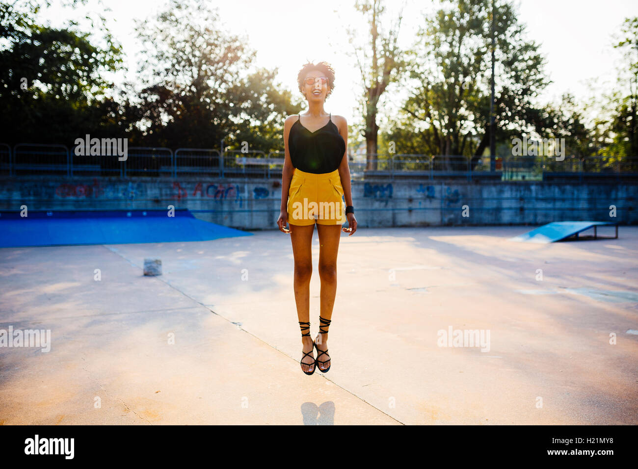 Junge Frau springt in die Luft in einem skatepark Stockfoto