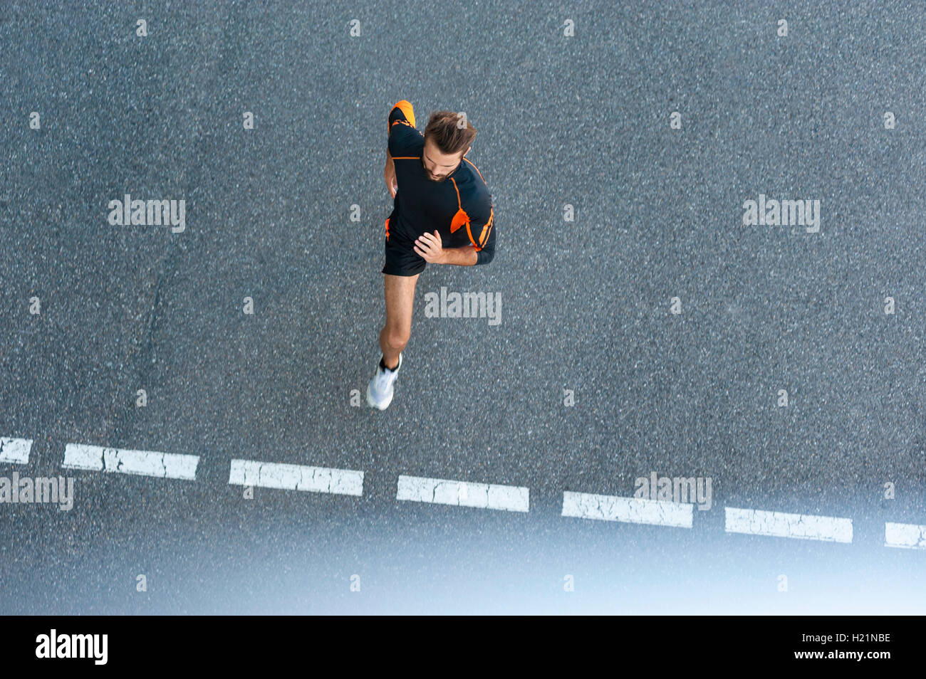 Mann läuft auf der Straße mit Markierungen Stockfoto