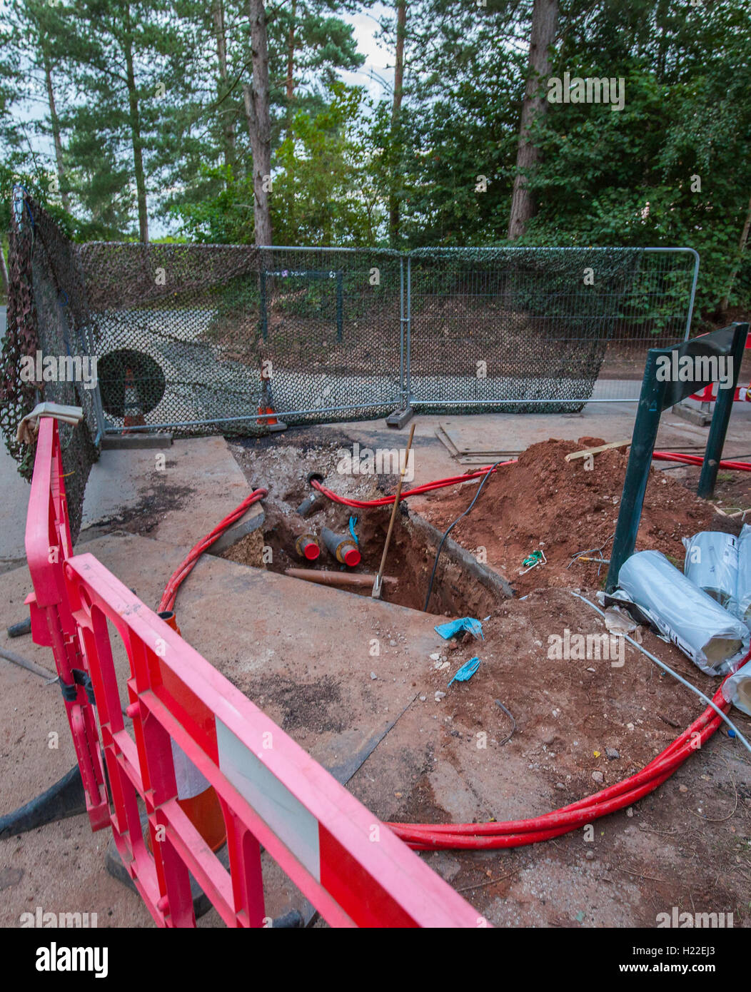 Ein Loch in den Boden für Versorgungsunternehmen ausgehoben Stockfoto