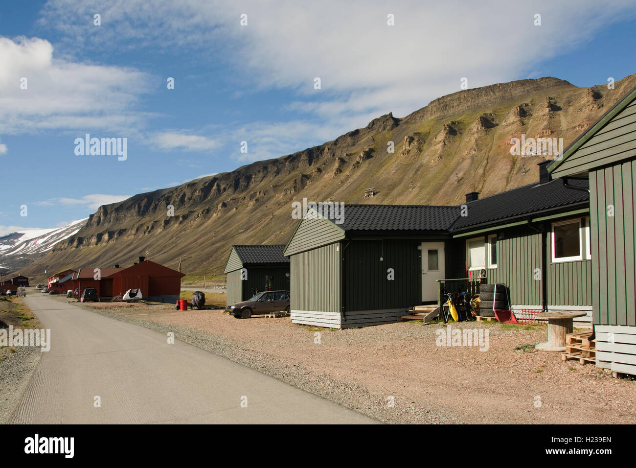 Europa, Norwegen, Svalbard (Spitzbergen), Longyearbyen, Hauptstraße mit typischen Gebäuden und Snow capped Berge hinter Stockfoto