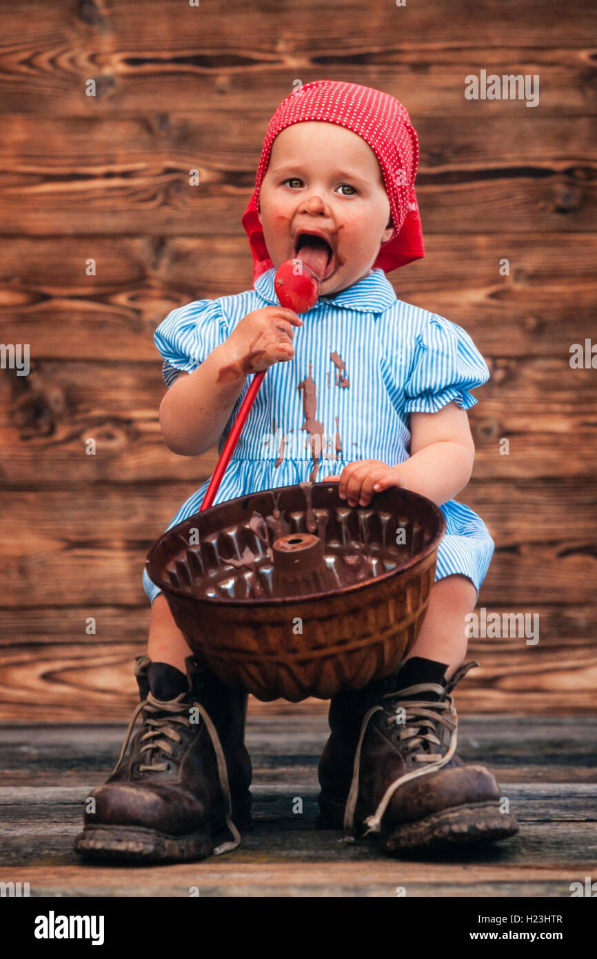 3-jähriges Mädchen essen Schokolade Kuchen Mischung aus Kuchenform,  verschmierte auf Gesicht, Österreich Stockfotografie - Alamy