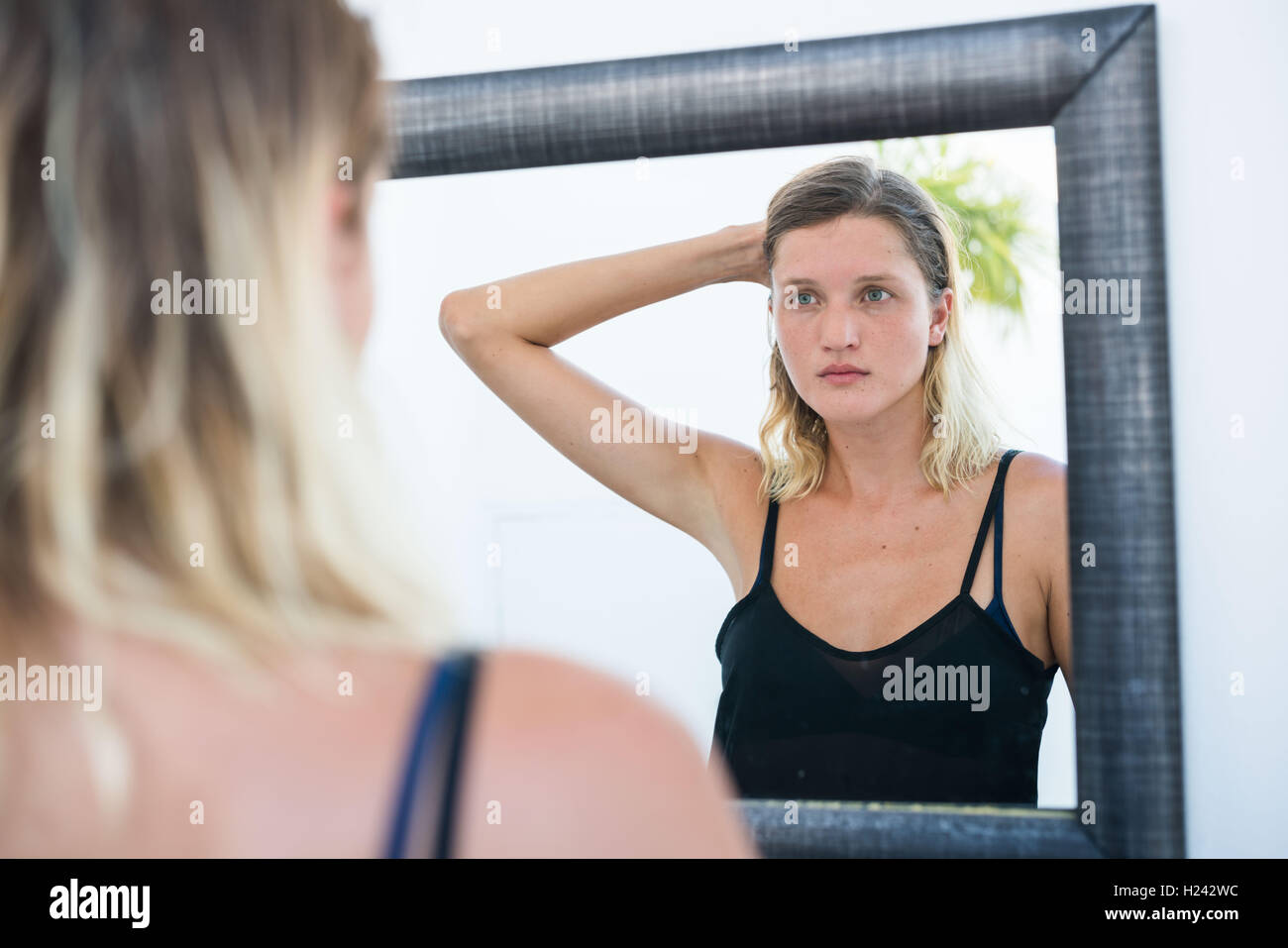 Frau ihr Gesicht im Spiegel zu überprüfen. Stockfoto