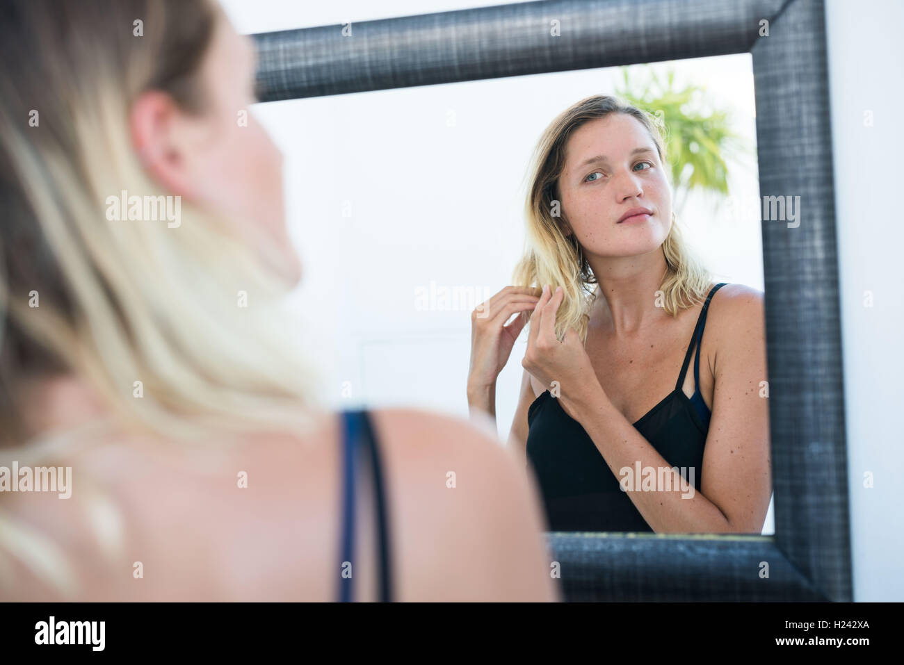 Frau ihr Gesicht im Spiegel zu überprüfen. Stockfoto