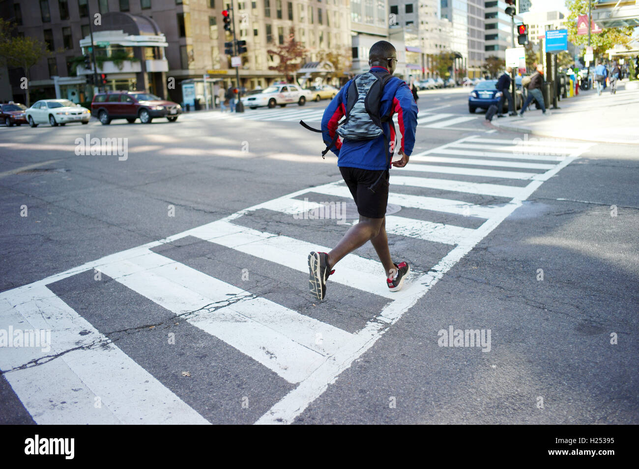 Ein Mann läuft Zebrastreifen in der Innenstadt von Washington DC. Stockfoto